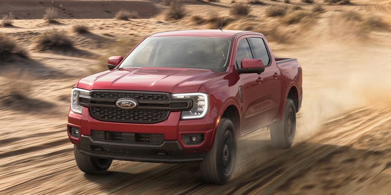 Red 2026 Ford Ranger driving on a dusty desert road