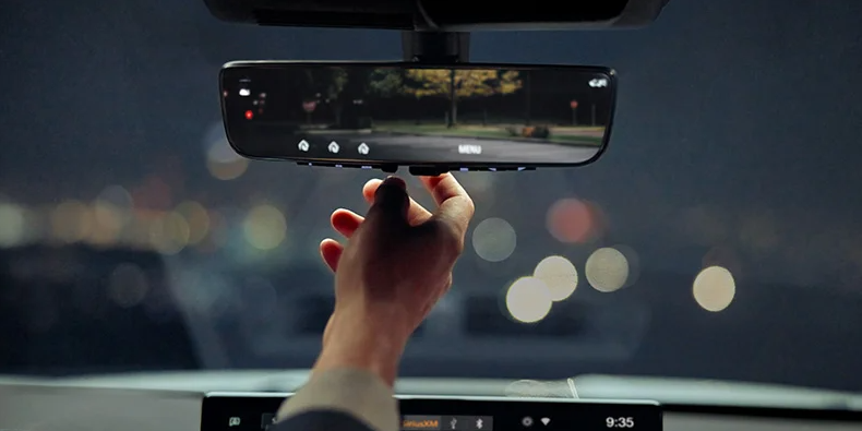Someone adjusting the read view mirror in a 2025 Mitsubishi Outlander.