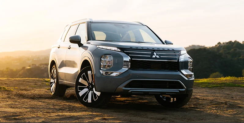 A 2025 Mitsubishi Outlander parked in a grass field. 