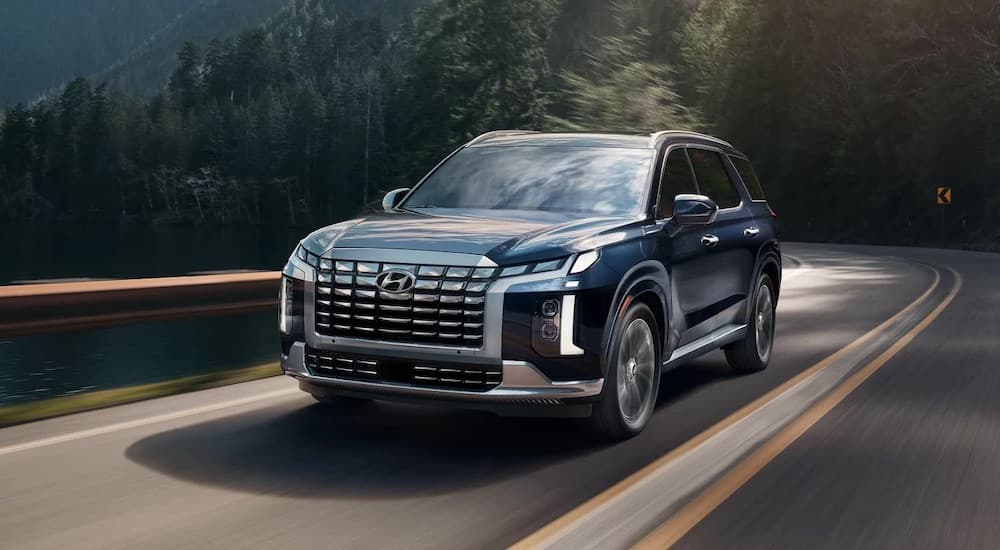 A blue 2025 Hyundai Palisade is shown from the front at an angle.