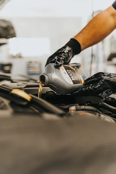 Car mechanic changing car oil