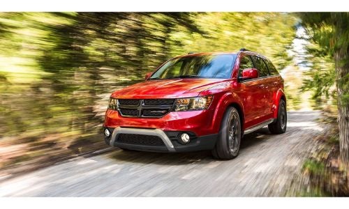 2020 Dodge Journey exterior shot with red paint color driving through a forest