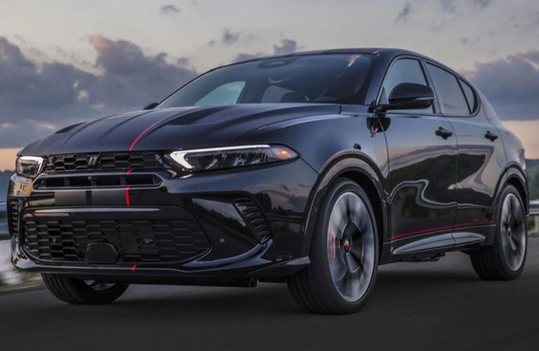 One black color 2023 Dodge Hornet is running on the road.