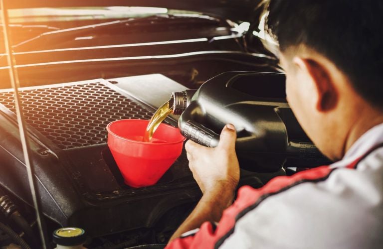 Service professional pouring oil from a can
