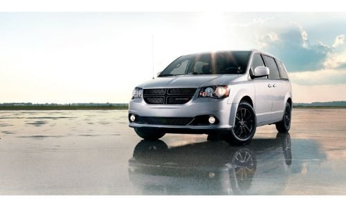 2020 Dodge Grand Caravan exterior shot with gray silver paint color parked on a wet ocean beach