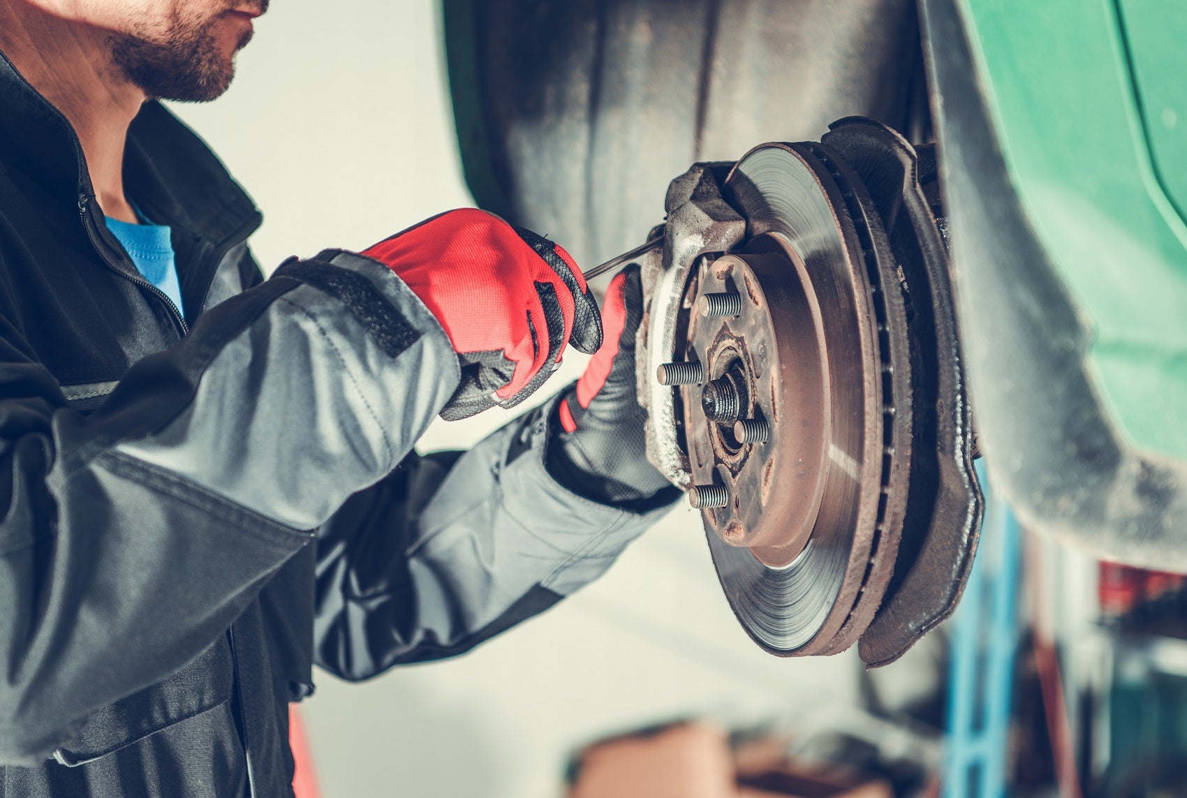 INFINITI technician inspecting brakes on a vehicle