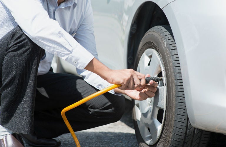 man checking tire pressure 