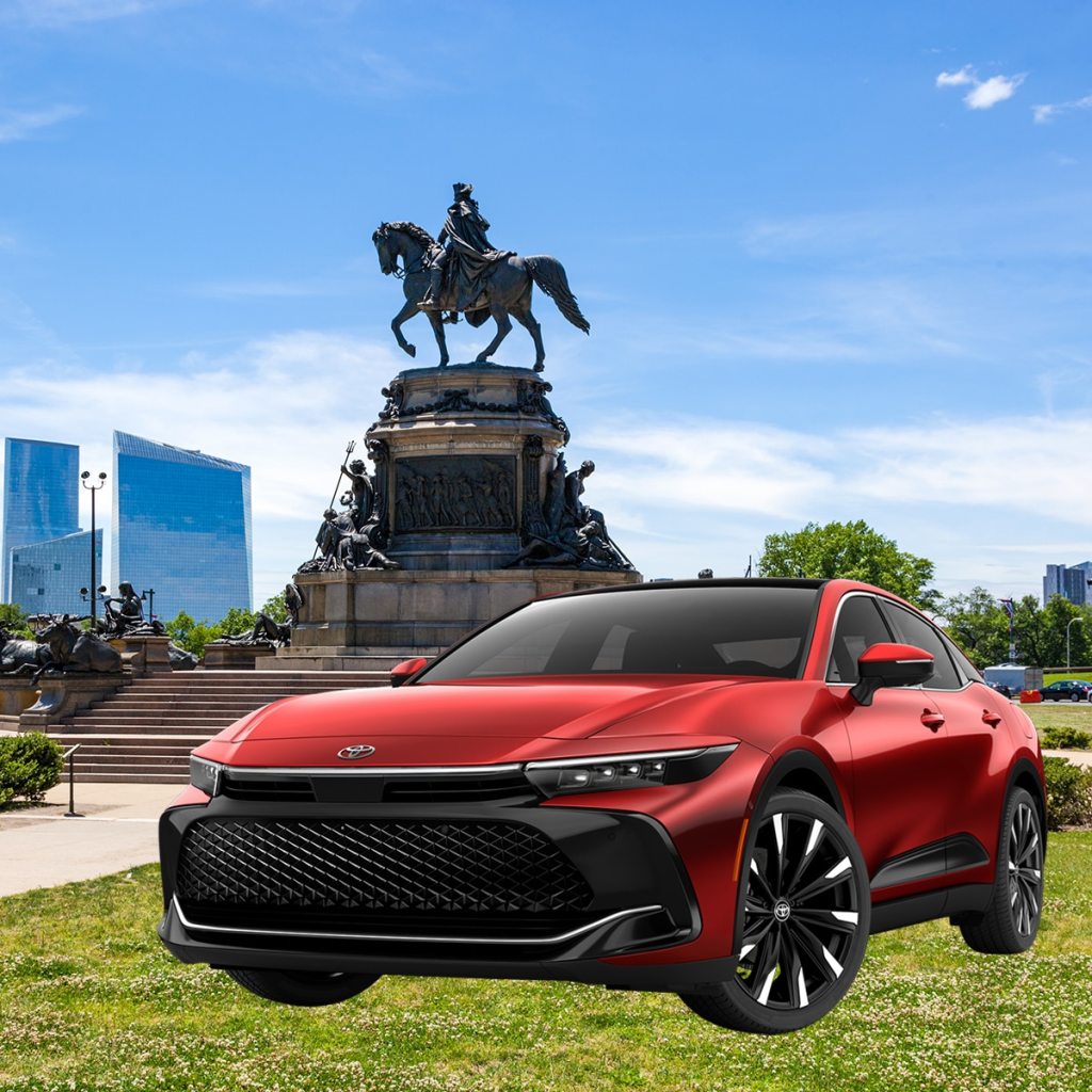 Super Sonic Red 2023 Toyota Crown Platinum Sedan in front of the Washington Monument at Eakins Oval in Philadelphia, Pennsylvania.