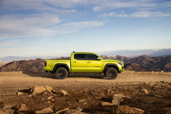 Green Toyota Tacoma on rocky mountain side view