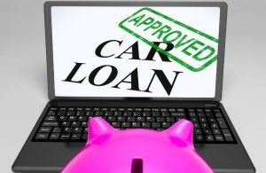 Laptop open showing car loan approved text