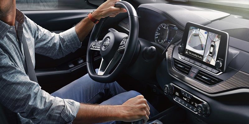 Interior view of a Nissan car with driver's hands on the steering
