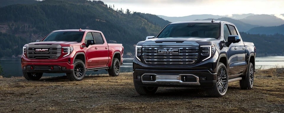 A red and black 2023 GMC Sierra 1500 parked next to each other.jpg