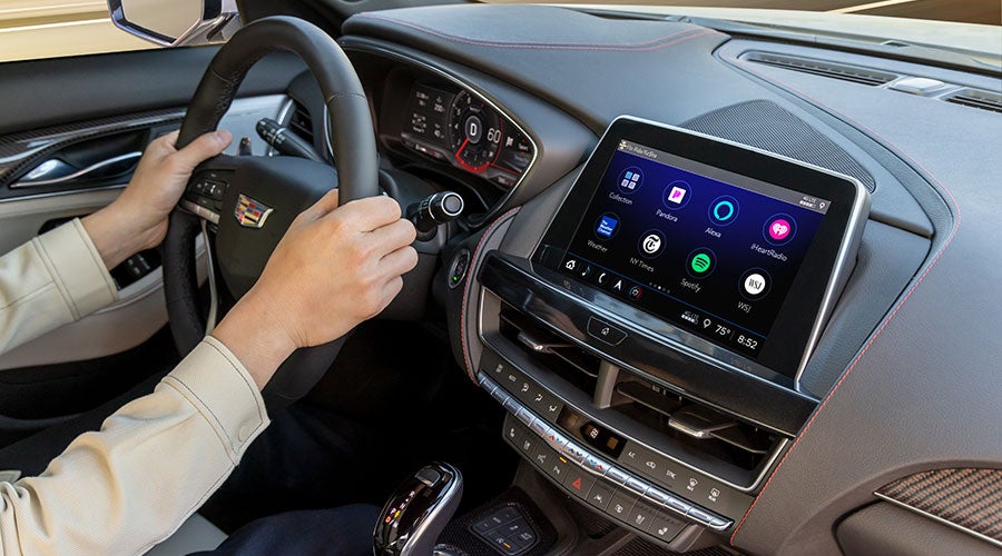 Driver using Cadillac touchscreen infotainment, highlighting AC system controls