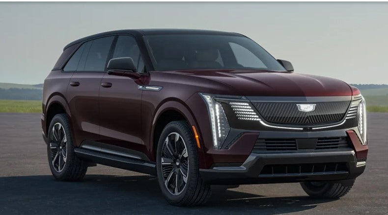 A burgundy Cadillac Escalade IQ SUV parked on an open road,