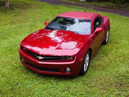 Red 2023 Chevy camaro parked in the grass