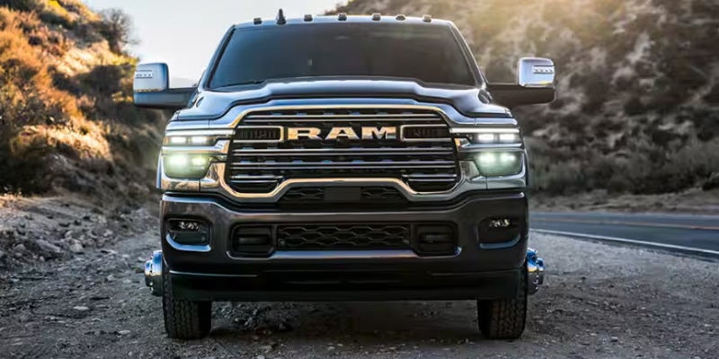 Front view of a dark grey Ram 3500 pickup truck parked on a dirt road.