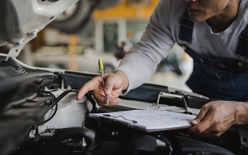 Technician inspecting car engine