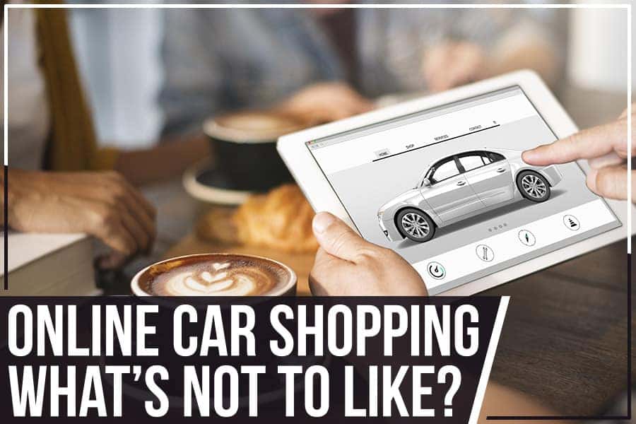 A person's hands holding a tablet with a car selection app open, alongside coffee cups and a book.