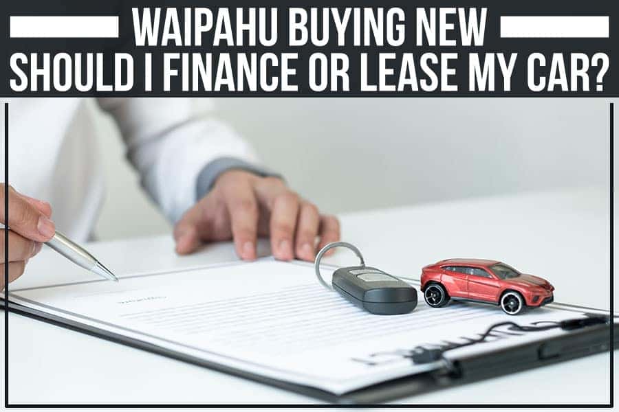 A person signing a car contract with a red toy car, car key, and calculator on the desk.