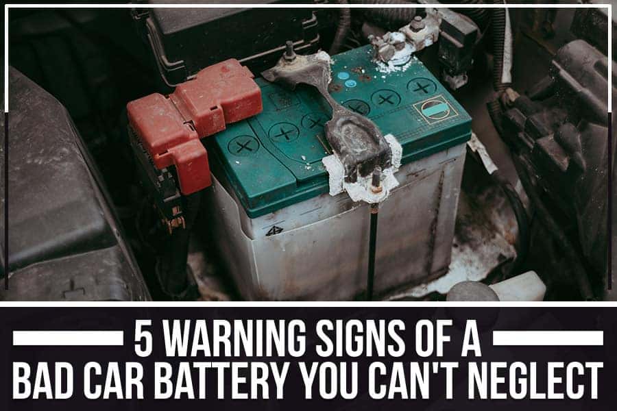 A close-up of a car engine bay, showing the car battery with components.