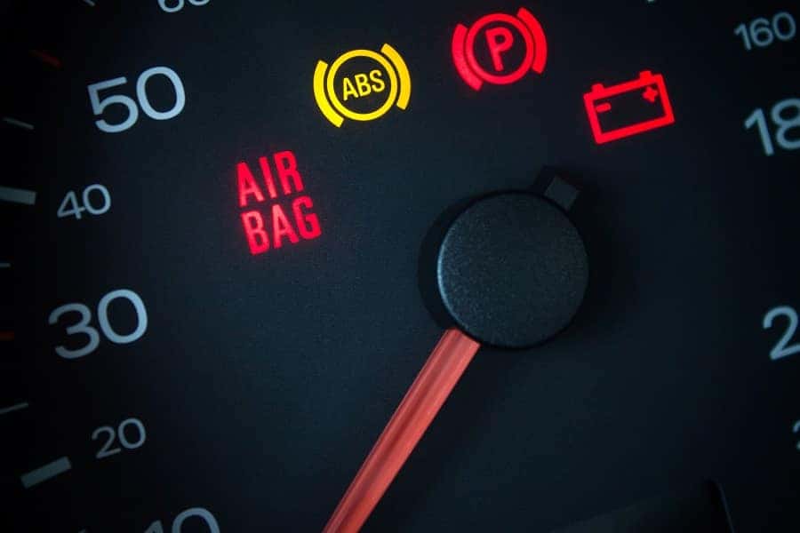 A car's dashboard with the check engine light illuminated, indicating a potential issue with the vehicle.