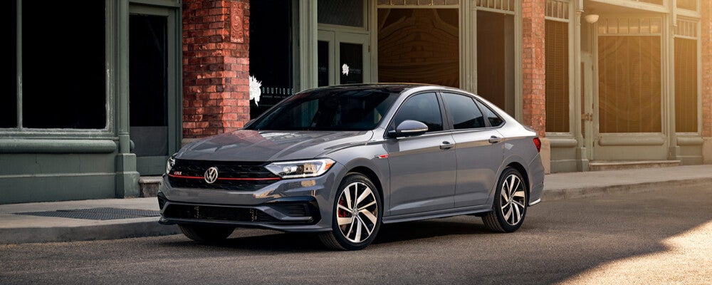 a grey volkswagen parked outside a building at dawn 