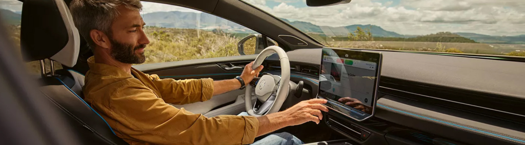 interior shot of a man driving in a car and about to accept a phone call 