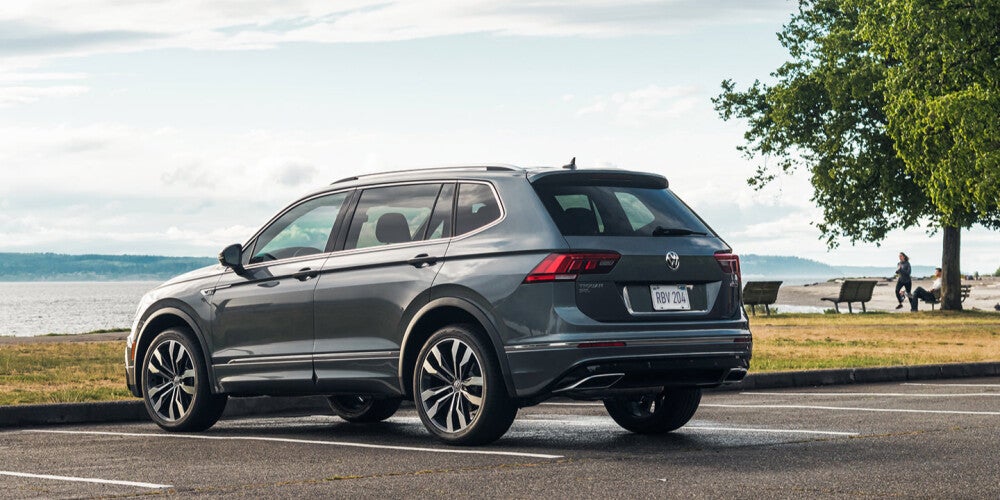 A silver volkswagen tiguan parked outside of a beach 