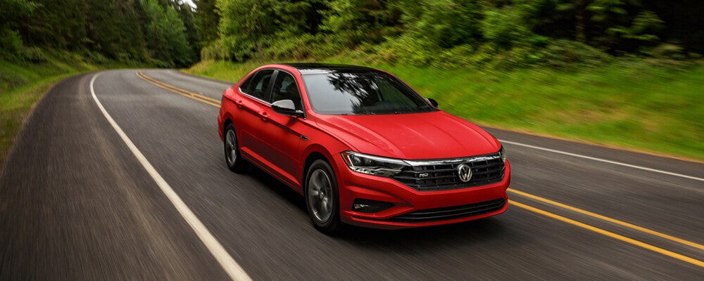 a red volkswagen speeding down a road 