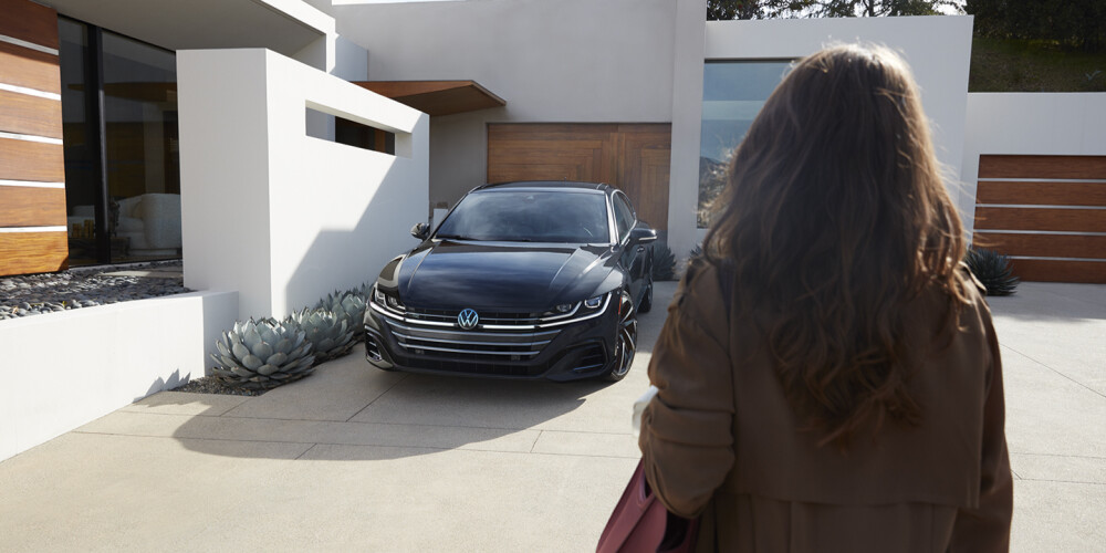woman facing towards a grey volkswagen 