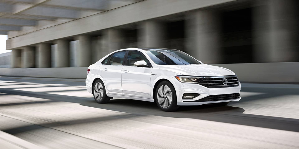 a white volkswagen jetta speeding on the highway 