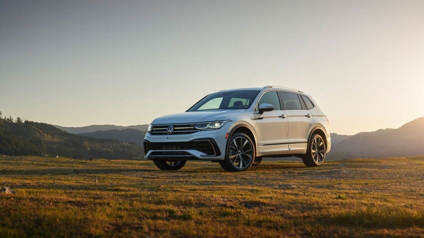 a volkswagen sits in a field at dawn 