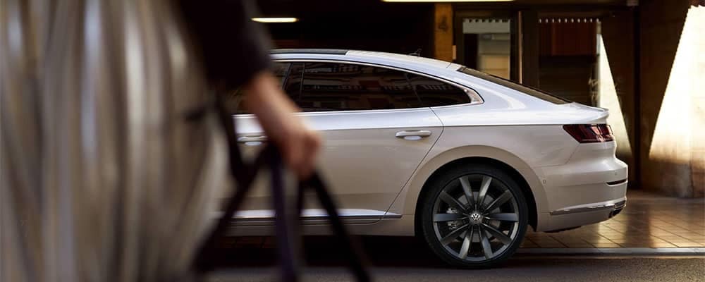 woman walking towards a volkswagen arteon 