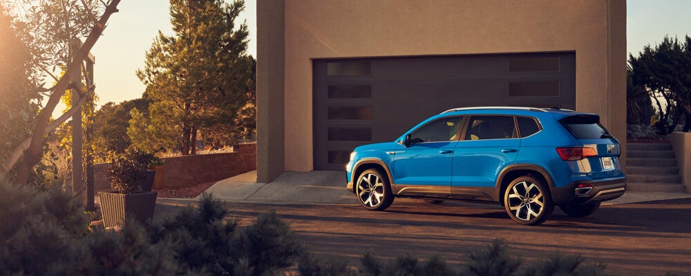 blue volkswagen parked by a house during sunset 