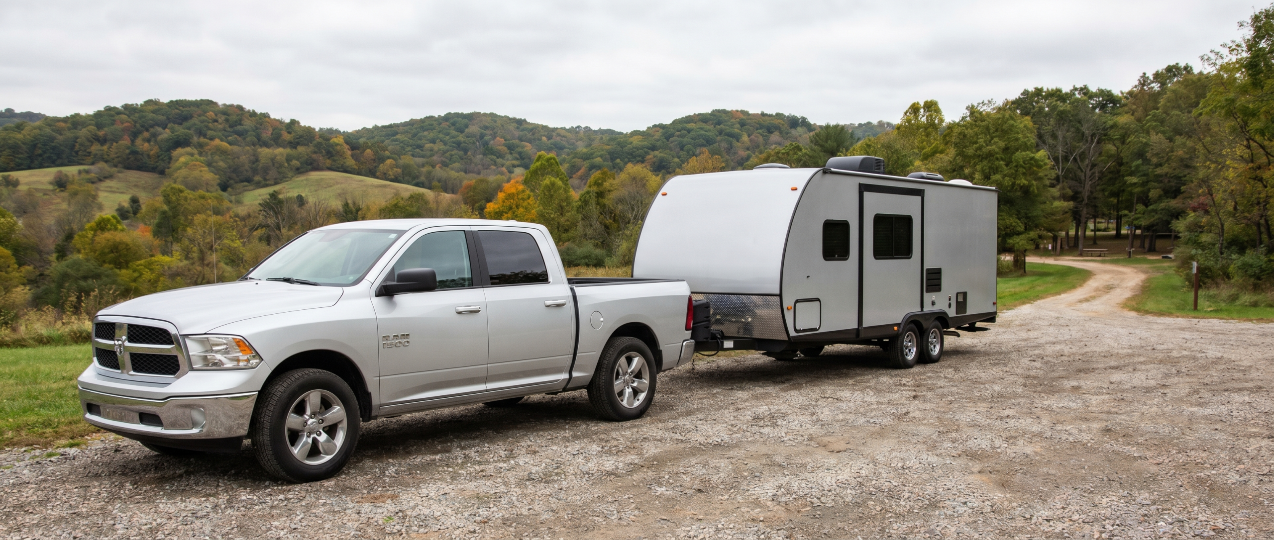 Pre-owned Ram 1500 with integrated trailer hitch towing a camper through Hampstead.