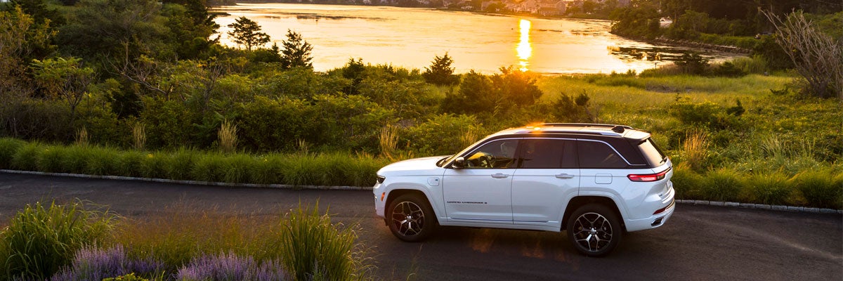 White Jeep Grand Cherokee 4xe White Summit Reserve Next to Lake During Sunset