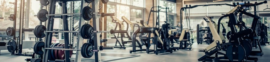 an empty gym at sunrise full of training equipment 