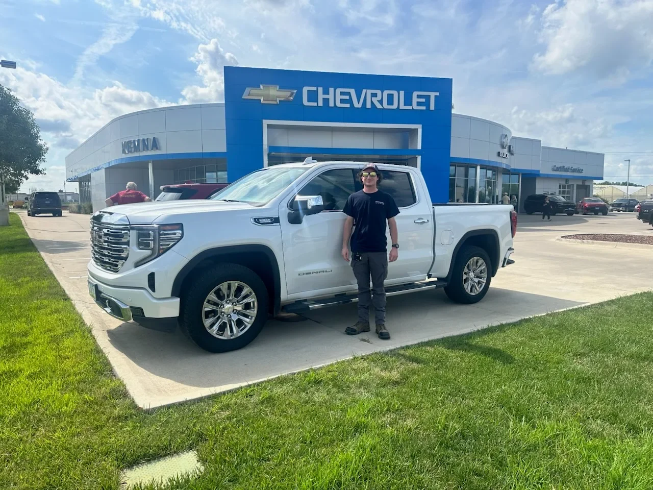 Kemna customer in front of the dealership with his new GMC Denali pickup truck