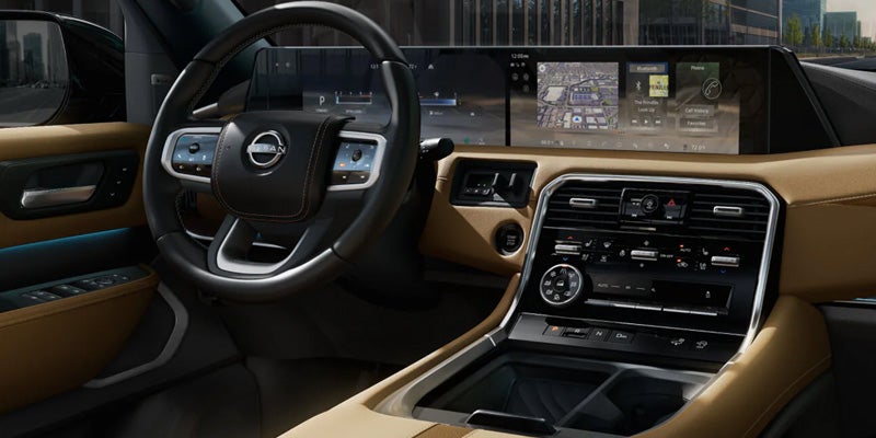 Nissan car interior with touchscreen and steering wheel.