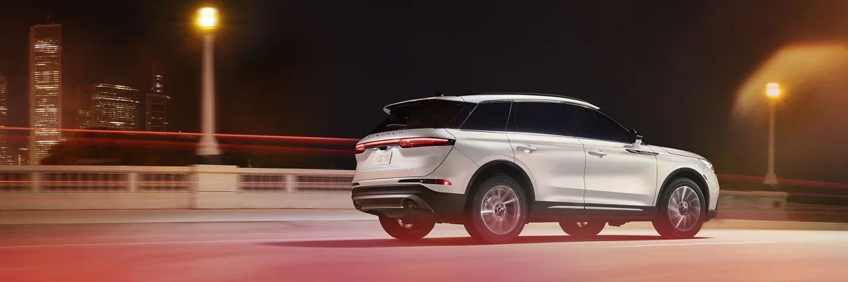 White Lincoln Corsair Driving on a Bridge at Night