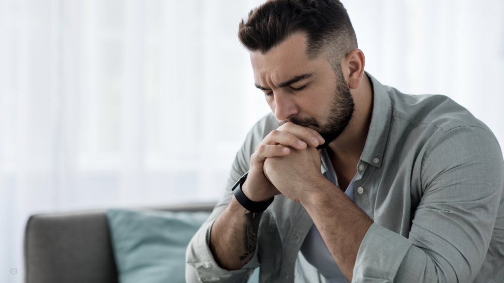 A sits with his chin in his hands.