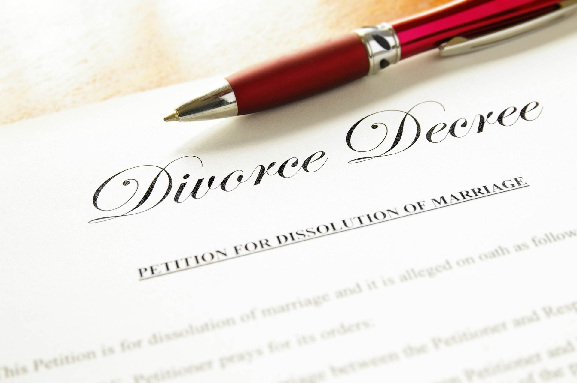 a red pen sits on top of divorce papers