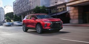 A red 2024 Chevy Blazer driving downtown. 