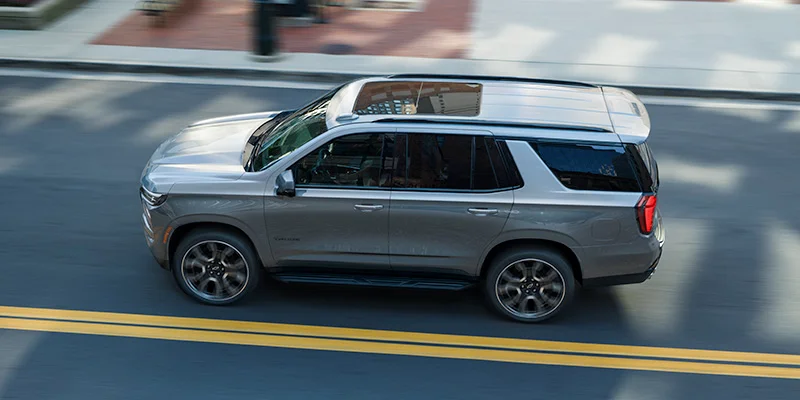 A silver 2025 Chevrolet Tahoe driving near Lake Orion