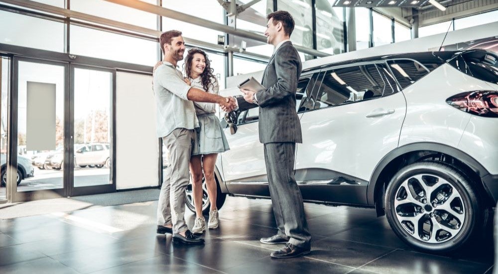 People shaking hands in a car dealership