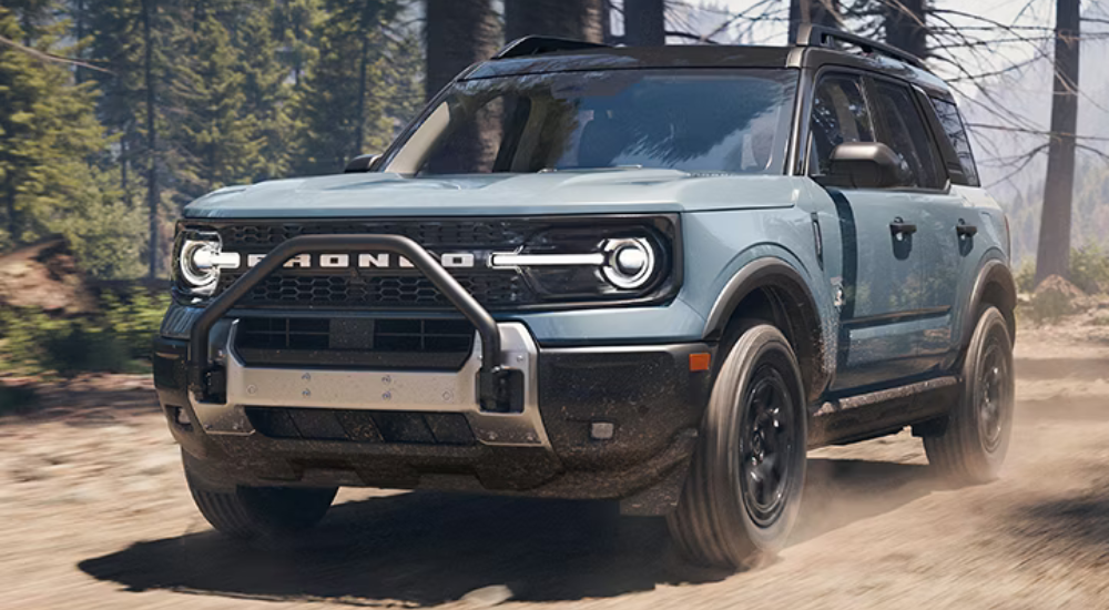 Blue 2026 Ford Bronco Sport Outer Banks driving through the woods