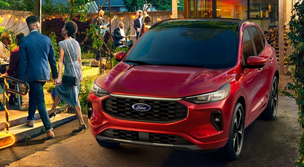 A red 2025 Ford Escape ST-Line parked near a party.