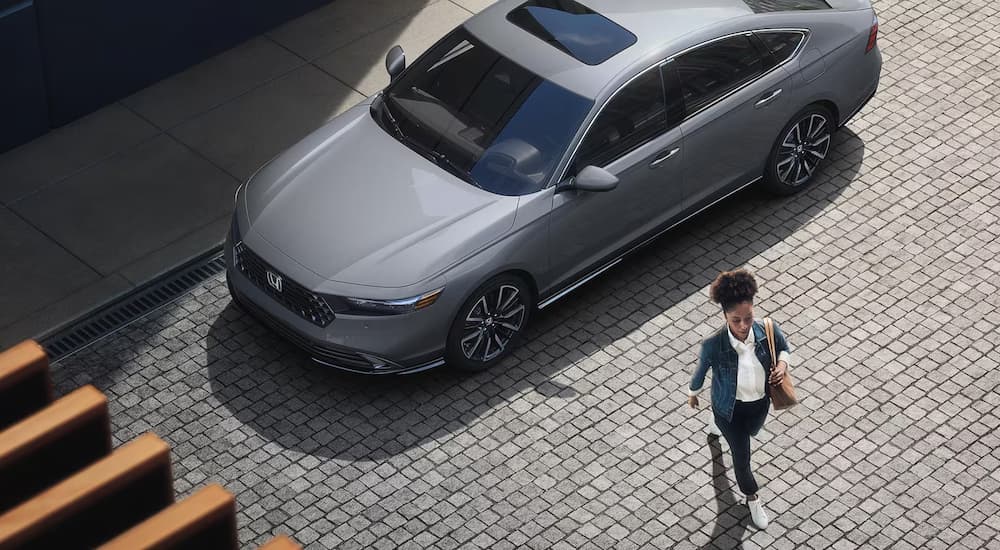 Grey 2026 Honda Accord Hybrid parked on the side of a city street