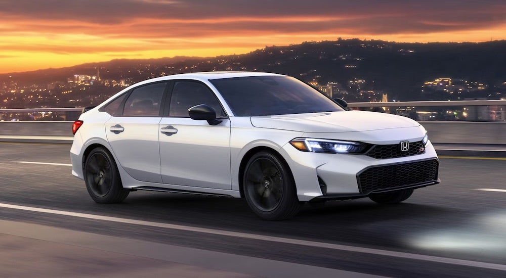 A white 2025 Honda Civic is shown from the side after leaving a Honda dealer near Naperville.