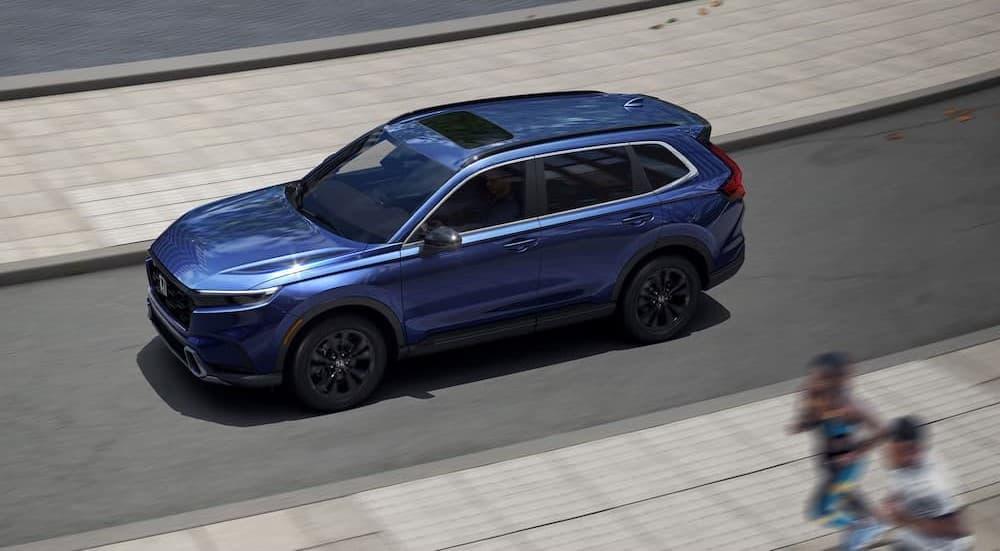 A blue 2025 Honda CR-V driving to a Honda dealer near Buffalo Grove.